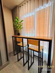 Compact dining area with high table and chairs next to a window