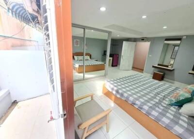 Spacious Bedroom with Large Mirror and Outdoor Access