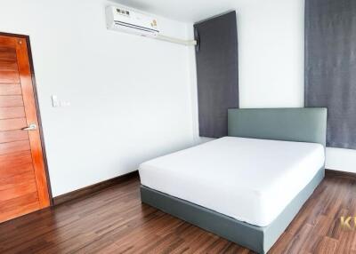 Modern furnished bedroom with wooden door and air conditioning