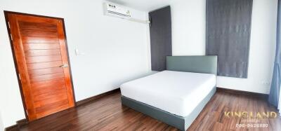 Modern furnished bedroom with wooden door and air conditioning