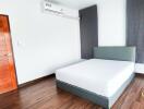 Modern furnished bedroom with wooden door and air conditioning