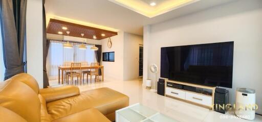 Modern living room with leather couch and large TV