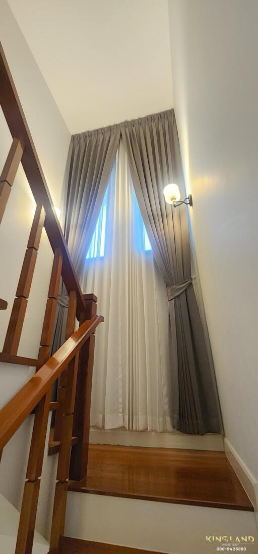 Stairway with wooden railing and curtains