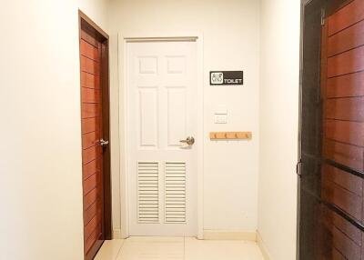 Bright hallway with white door and wooden doors