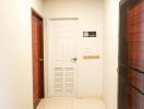 Bright hallway with white door and wooden doors