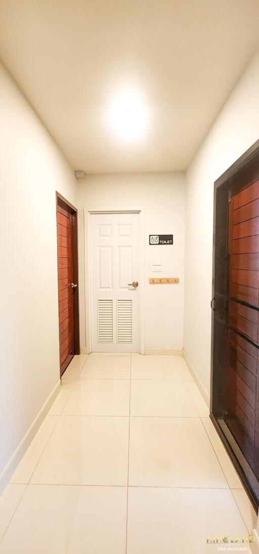 Bright hallway with white door and wooden doors