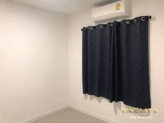 Bedroom with curtained window and air conditioning