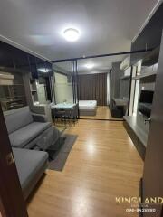 Photo of a modern studio apartment with open-plan living area, dining space, and visible bedroom