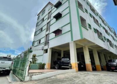 Exterior view of a multi-story residential building with parking area