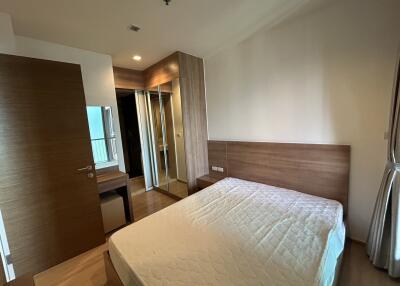 Bedroom with a double bed, wooden headboard, and mirrored wardrobe