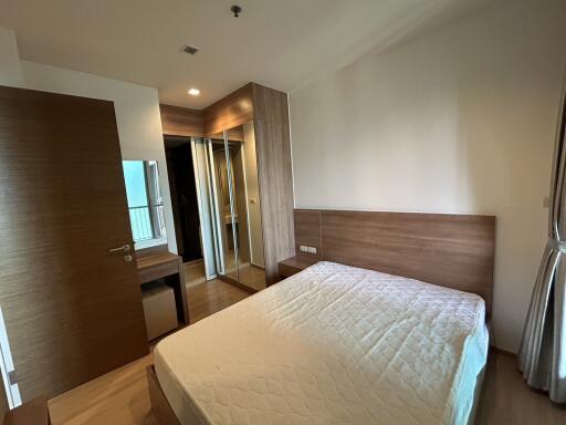 Bedroom with a double bed, wooden headboard, and mirrored wardrobe