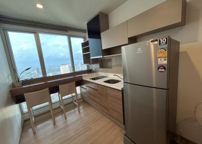 Modern kitchen with large window, light wood flooring, and stainless steel appliances