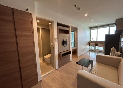 Modern living room with adjacent bathroom and kitchenette