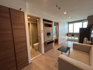 Modern living room with adjacent bathroom and kitchenette