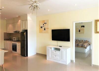 Modern living room with open kitchen and a view of a bedroom