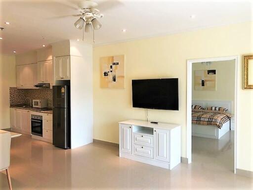 Modern living room with open kitchen and a view of a bedroom