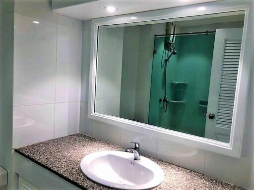 Modern bathroom with granite countertop and large mirror