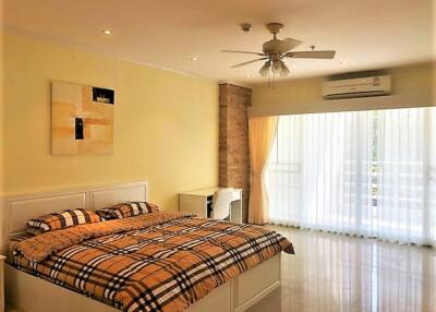 Spacious bedroom with double bed and large windows