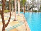 Swimming pool area with trees and loungers