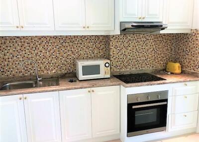 Modern kitchen with white cabinets and mosaic backsplash