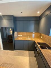 Modern kitchen with dark cabinetry and wooden countertops