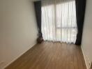 Empty bedroom with large window and curtains