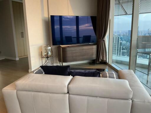 Modern living room with city view, large TV, and sectional sofa