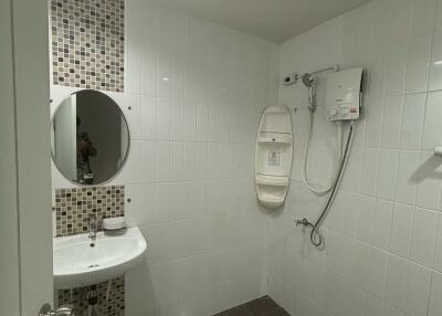 Modern bathroom with shower, sink, and tiled wall