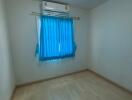 empty bedroom with blue curtains and air conditioning