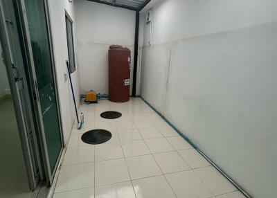 Covered utility area with tiled flooring and storage space