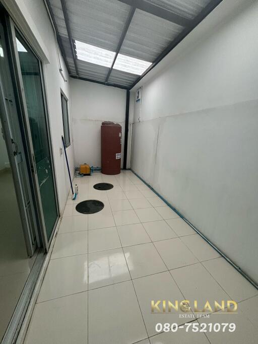 Covered utility area with tiled flooring and storage space