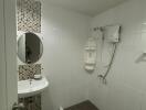 Bathroom with sink, mirror, shower area, and tiled walls