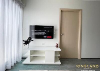 Living room with mounted TV and white curtain