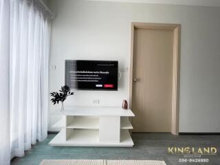 Living room with mounted TV and white curtain