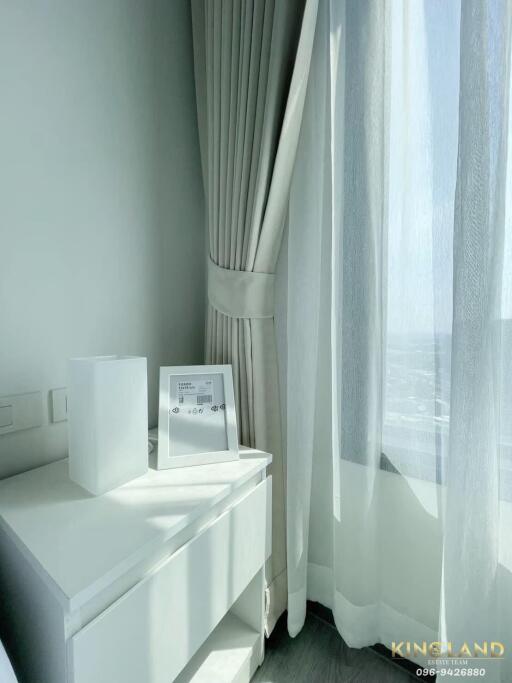 Modern bright bedroom corner with white curtains and a nightstand