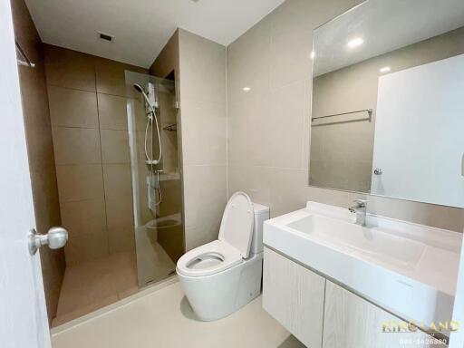 Modern bathroom with walk-in shower, toilet, and sink