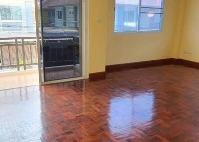 Spacious living room with shiny wooden floor and large windows.