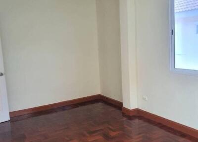 Empty bedroom with wooden parquet flooring and window