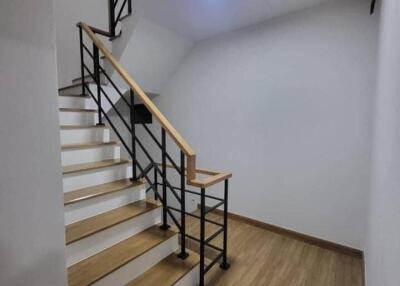 Modern staircase with wooden steps and metal railing