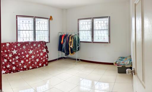 Spacious bedroom with tiled flooring and windows