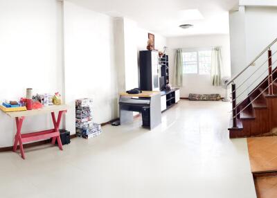 A spacious living room with modern furniture and staircase