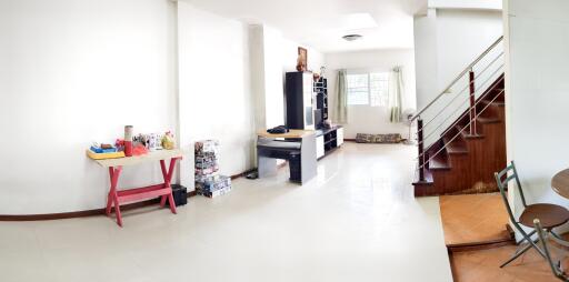 A spacious living room with modern furniture and staircase