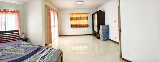 Spacious bedroom with large windows and ample storage