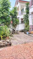 Well-maintained outdoor area with greenery and tiled patio