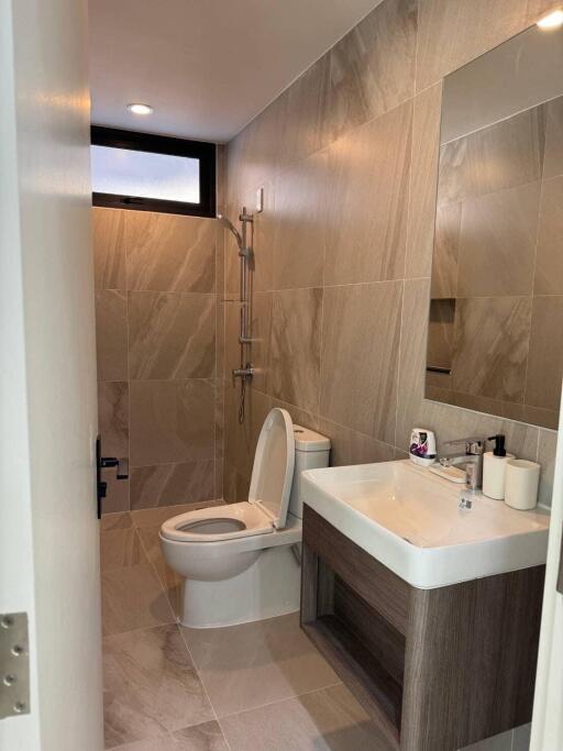 Modern bathroom with sink, toilet, mirror, and shower