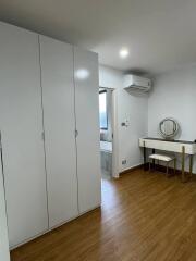 Modern bedroom with white closet, wooden floor, and bathroom access