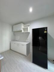 Modern kitchen with black refrigerator and white cabinetry