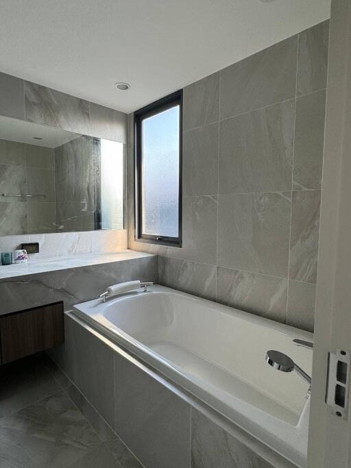 Modern bathroom with bathtub and large mirror