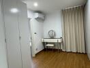 Minimalist bedroom with hardwood flooring and vanity table