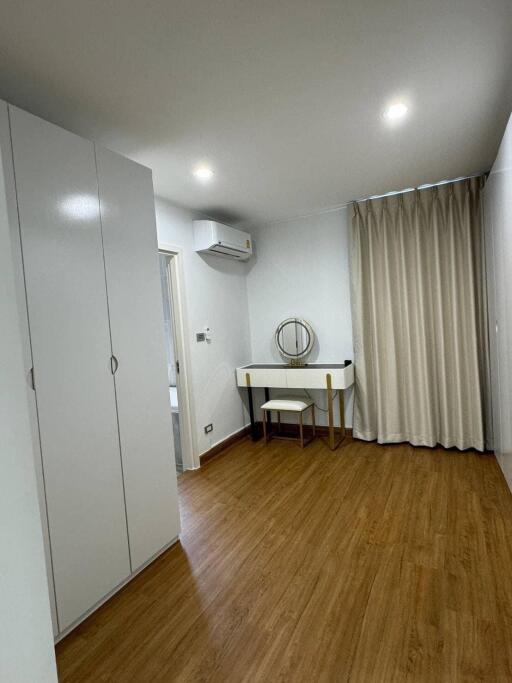 Minimalist bedroom with hardwood flooring and vanity table